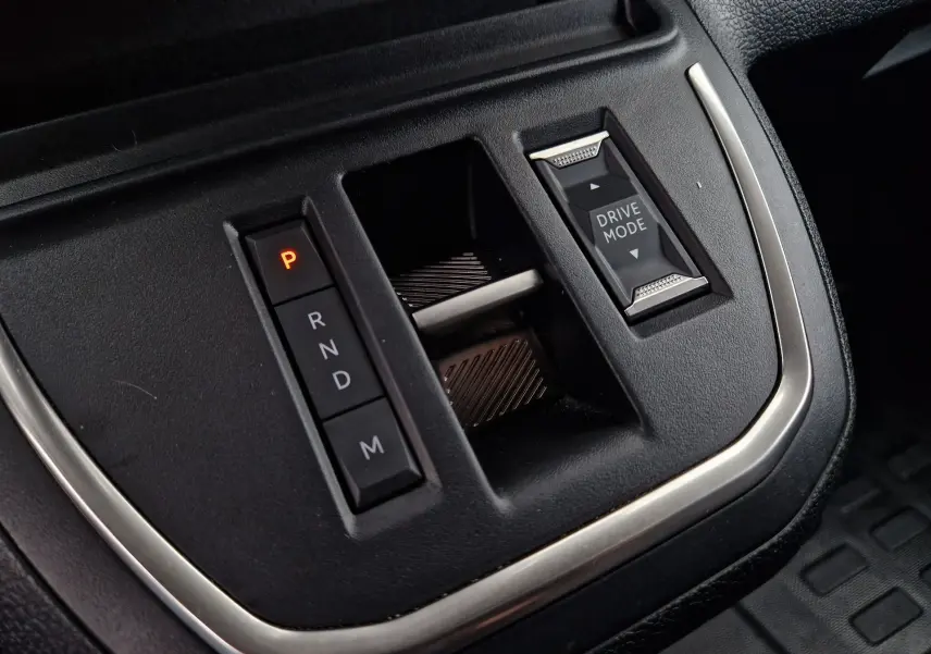 Gros plan sur la console centrale noire du Fiat Scudo Fourgon 2024 montrant la sélection de boîte auto et le bouton Drive Mode.