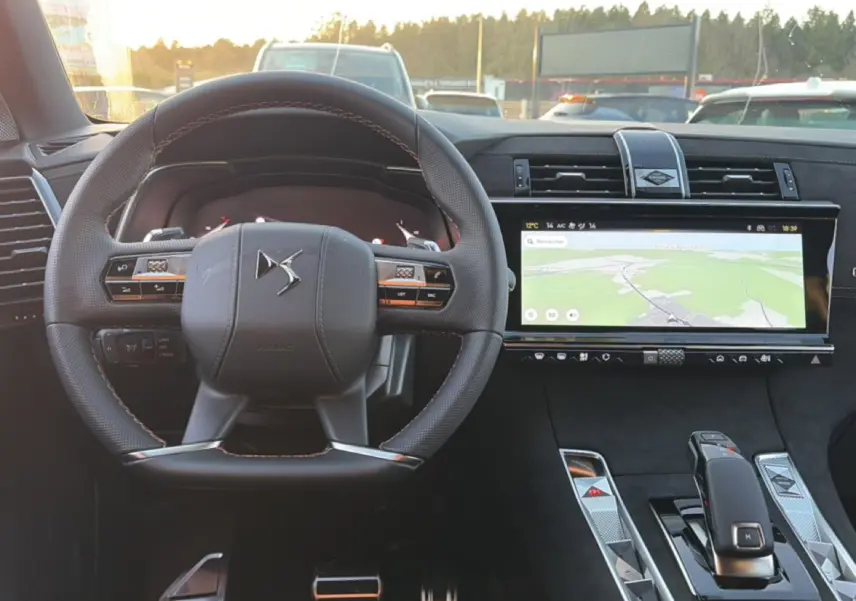 Vue intérieure centrée sur le volant cuir et l'écran tactile large du tableau de bord du DS7 noir 2026.