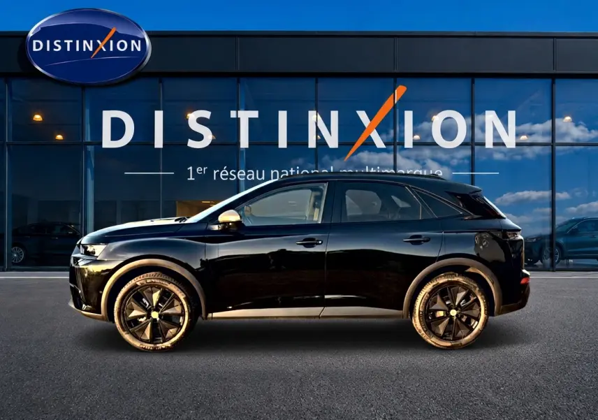Vue latérale droite d'un DS7 noir 2026 garé devant une vitrine avec logo Distinxion en arrière-plan.