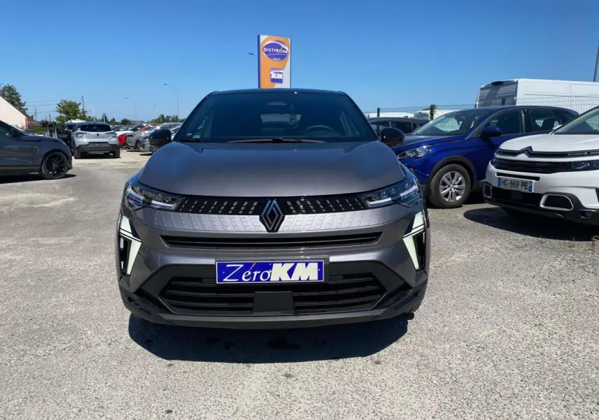Vue de face du Renault Captur 2025 gris Cassiopée avec toit noir, affichant sa calandre distinctive et ses phares LED fins.