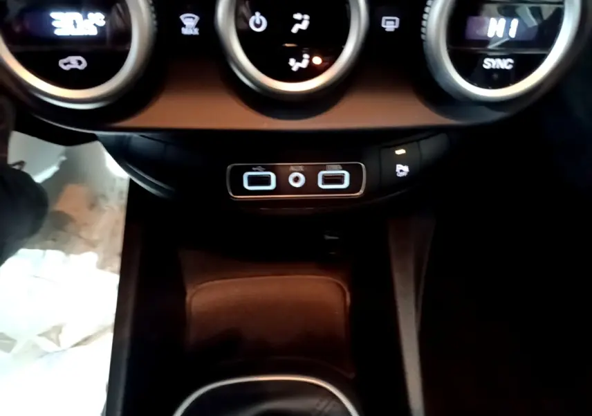 Vue rapprochée du tableau de bord et des commandes de climatisation du Fiat 500X gris foncé, avec ports USB et auxiliaire visibles.