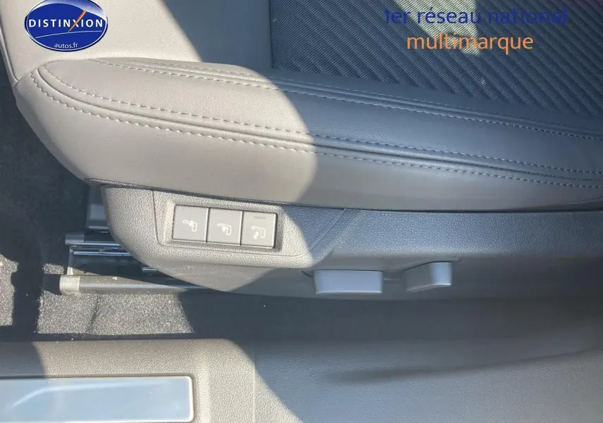 Gros plan sur le côté gauche d’un siège avant gris clair avec commandes électriques dans l’Alfa Romeo Junior 1.2 hybride 2026.