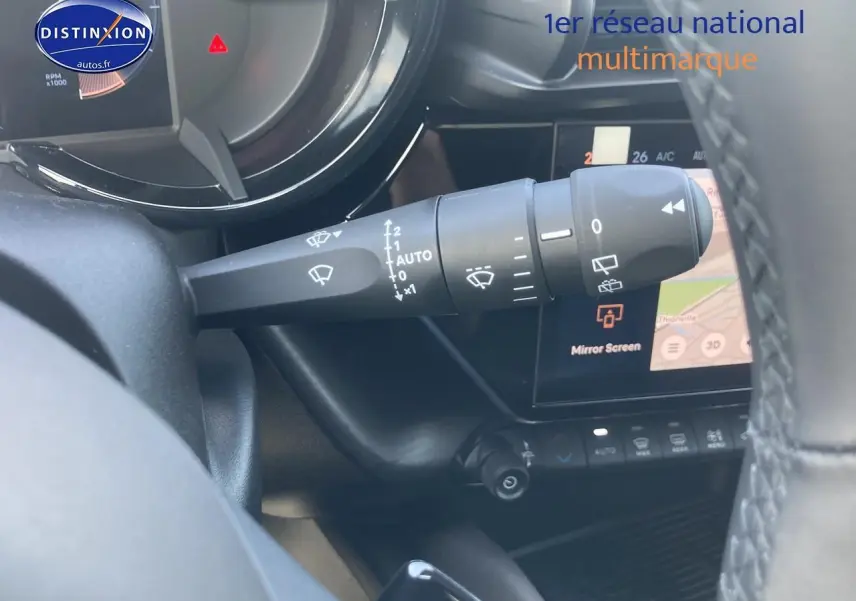 Gros plan sur le commodo d’essuie-glace côté gauche de l’intérieur d’une Alfa Romeo Junior gris/noir avec écran tactile visible.