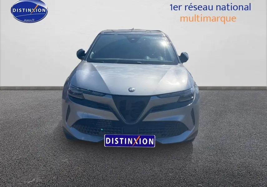 Vue frontale d'une Alfa Romeo Junior 1.2 hybride gris t/noir avec calandre caractéristique et phares LED matrix.