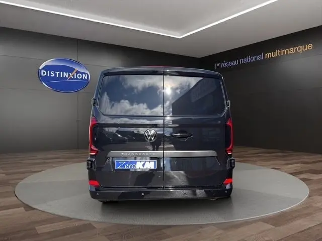 Vue arrière d’un Volkswagen Transporter noir 2026, avec portes battantes fermées et logo VW visible.