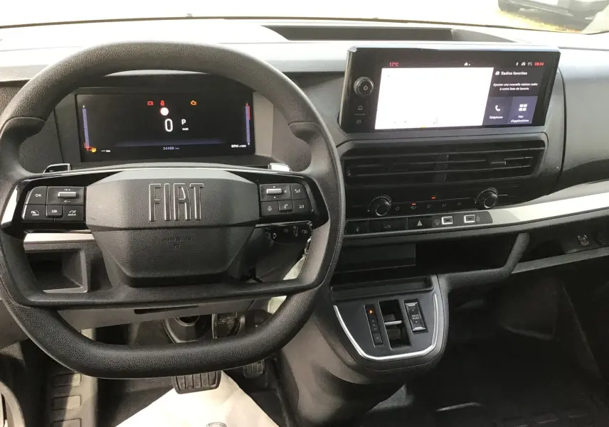 Vue intérieure du tableau de bord du Fiat Scudo Fourgon 2024, avec volant noir et écran tactile central lumineux.