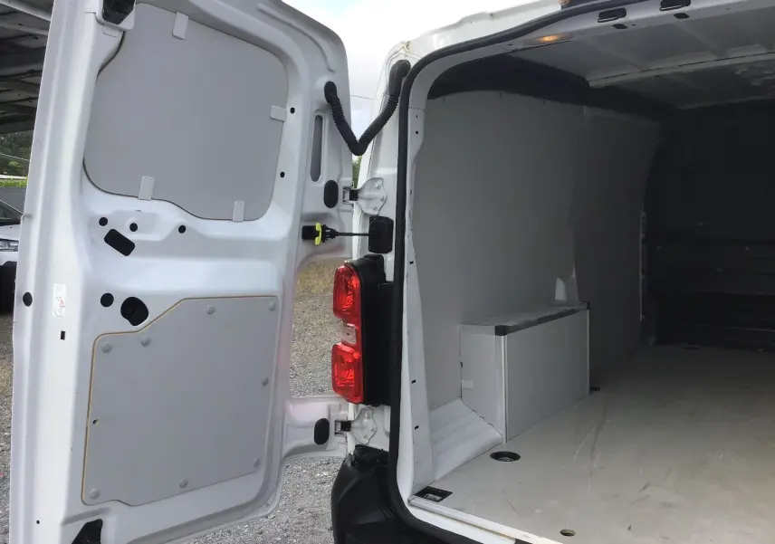 Vue arrière intérieure du FIAT Scudo Fourgon blanc 2024, portes ouvertes montrant l’espace de chargement vide avec cloison partielle.