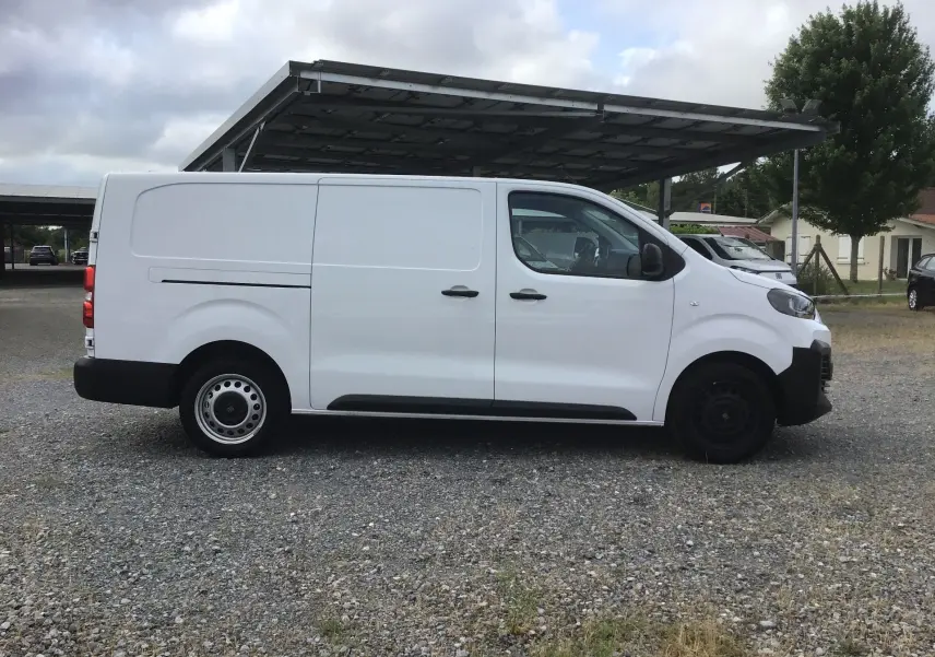 Vue latérale droite d’un FIAT Scudo Fourgon blanc 2024, version XL avec garde au sol réhaussée et plaque de protection.