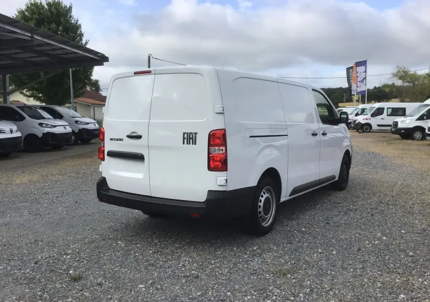 Vue 3/4 arrière droite d’un FIAT Scudo Fourgon blanc 2024 avec garde au sol réhaussée et plaque de protection.