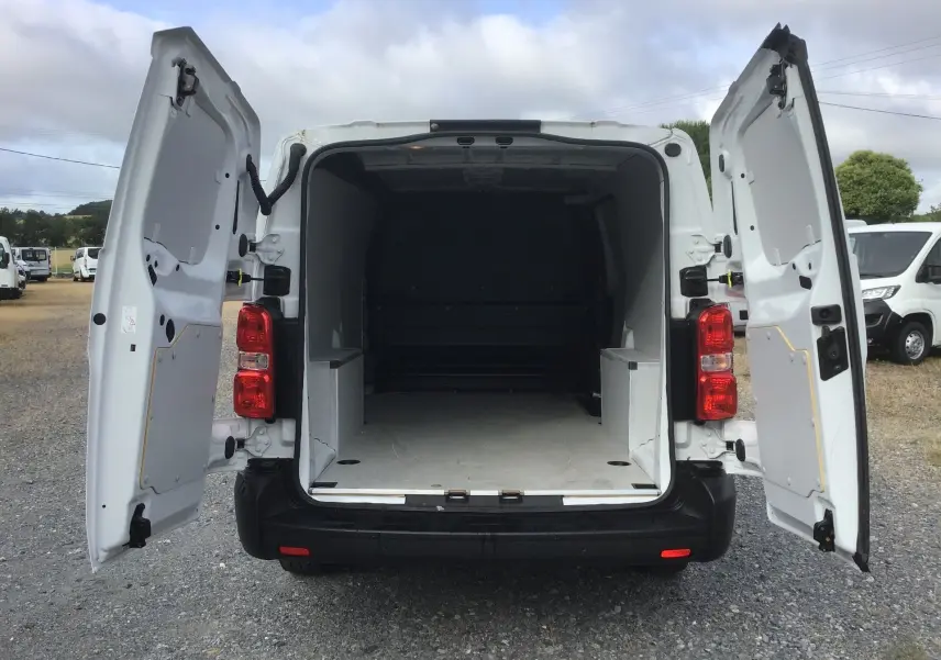 Vue arrière du FIAT Scudo Fourgon blanc 2024 avec portes arrière ouvertes montrant l’espace de chargement vide.