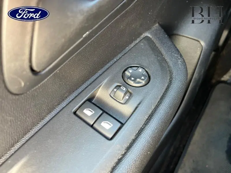 Gros plan sur les commandes de vitres électriques côté conducteur d'un Peugeot 208 Affaire blanc Banquise, intérieur noir.