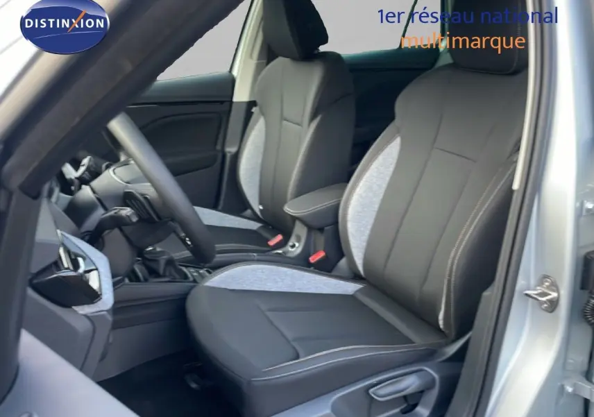 Vue intérieure côté conducteur du Skoda Kamiq gris argent, mettant en valeur les sièges bi-matière noir et gris clair.