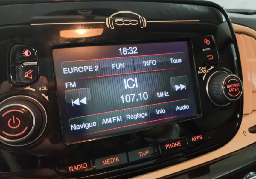 Écran tactile central noir de la Fiat 500 2018 affichant une radio FM avec commandes autour et logo 500 au-dessus.