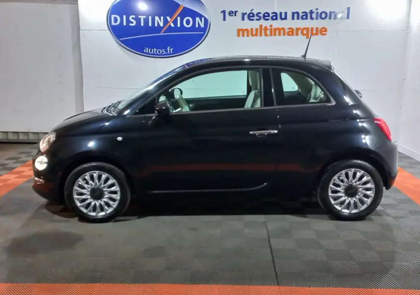 Profil côté gauche de la Fiat 500 noire de 2018, finition Lounge, avec jantes alliage et intérieur clair visible.