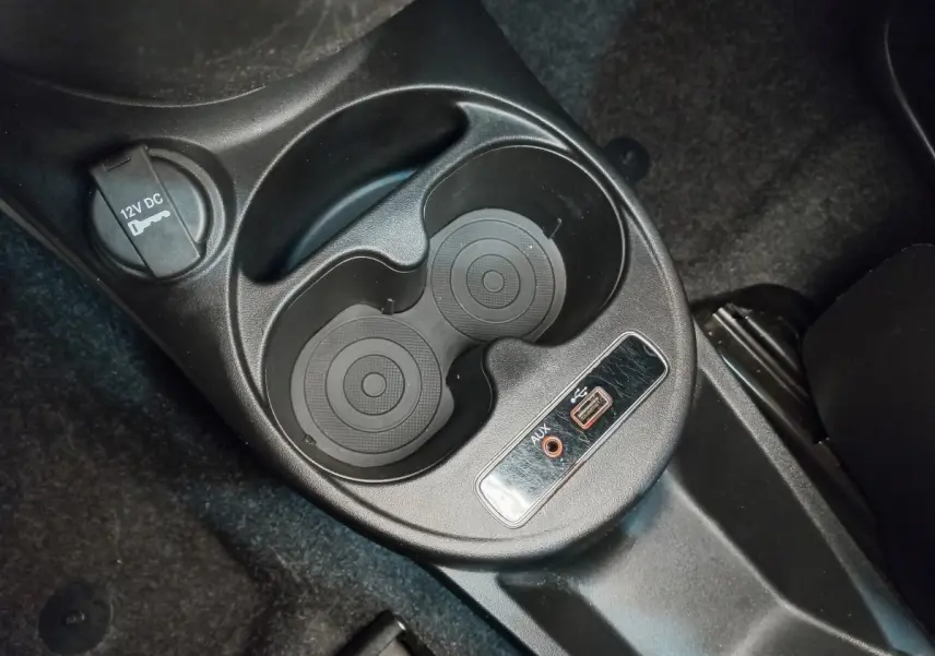 Gros plan sur la console centrale noire de la Fiat 500 Lounge 2018 avec prises USB, AUX et porte-gobelets.
