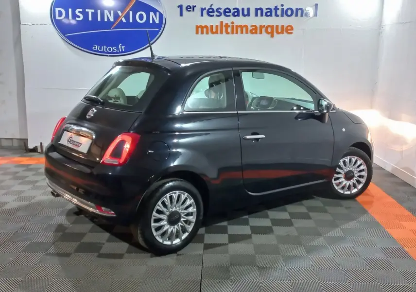 Vue 3/4 arrière droite d'une FIAT 500 noire Lounge 2018, avec feux arrière allumés et jantes argentées.