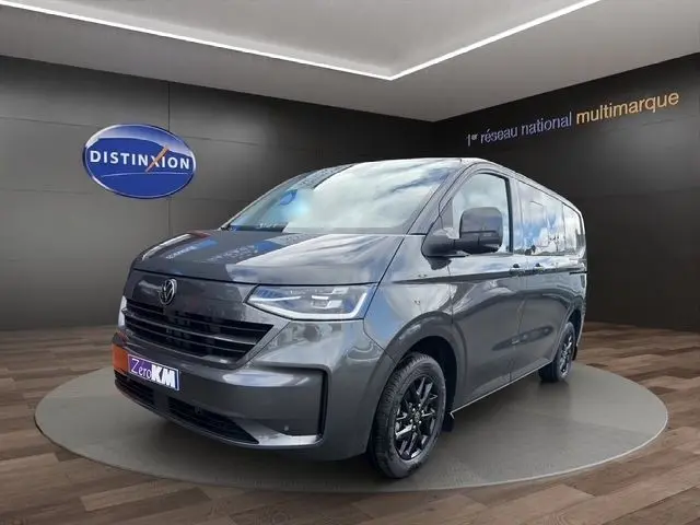 Volkswagen Transporter gris foncé en 3/4 avant droit, avec jantes noires et calandre noire brillante.