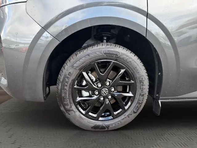 Gros plan sur la roue avant droite noire brillante du Volkswagen Transporter gris foncé, mettant en valeur la jante et le pneu Goodyear.