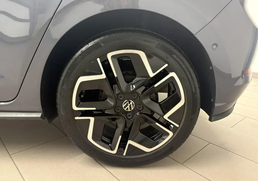 Gros plan sur la roue arrière droite d'une Volkswagen Polo gris cendré avec jante noire et détails argentés R-Line.