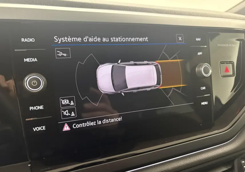 Écran du système d'aide au stationnement de la Volkswagen Polo 1.0 TSI R-Line, affichant une vue aérienne du véhicule gris cendré.
