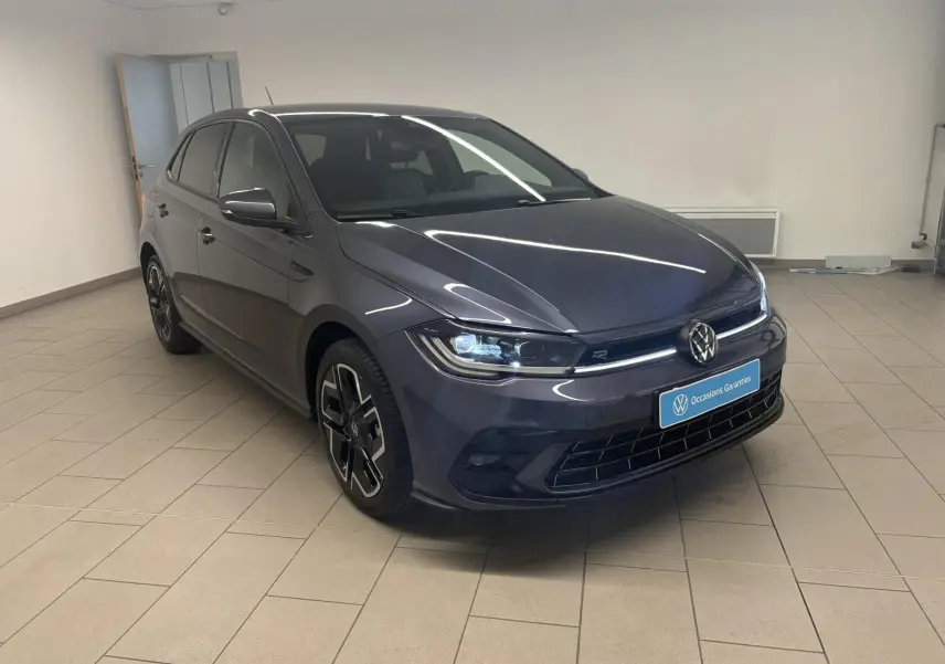 Volkswagen Polo 1.0 TSI R-Line gris cendré vue 3/4 avant droit en intérieur avec jantes spécifiques R-Line.