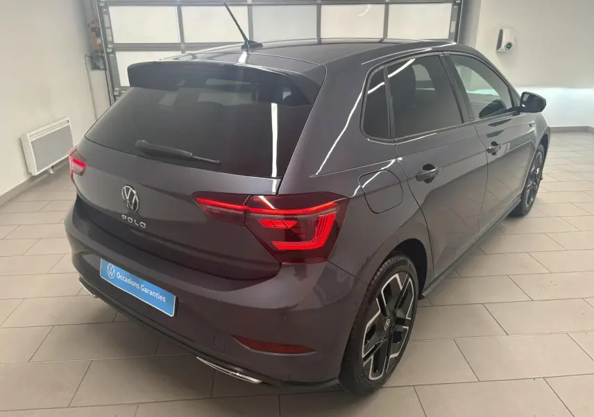 Volkswagen Polo 1.0 TSI R-Line gris cendré vue 3/4 arrière droit en intérieur avec jantes noires distinctives.