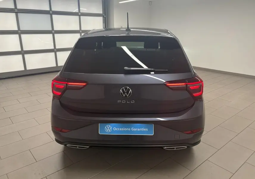 Vue arrière d'une Volkswagen Polo 2025 gris cendré avec feux LED allumés et double sortie d'échappement chromée.