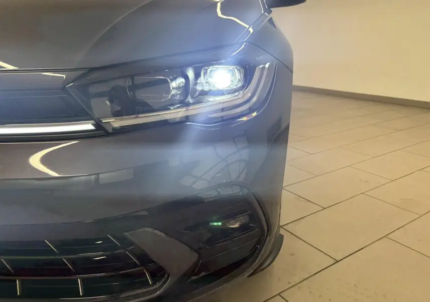 Gros plan sur le phare avant droit allumé d'une Volkswagen Polo 2025 gris cendré avec finition R-Line.