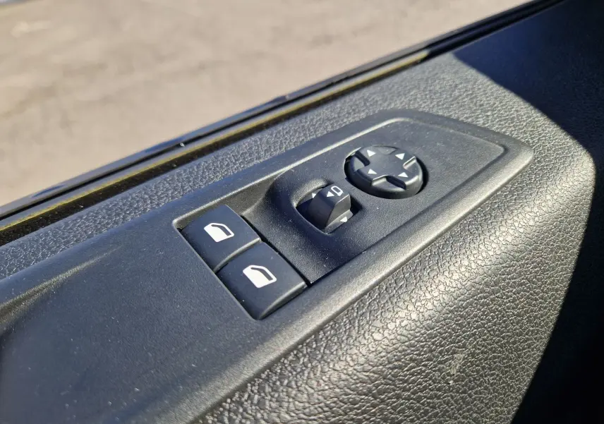 Détail des commandes de réglage des rétroviseurs et des vitres côté conducteur du FIAT Scudo Fourgon blanc 2024.