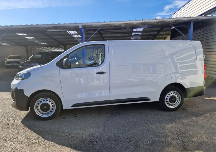 Vue de profil côté gauche d'un FIAT Scudo Fourgon blanc 2024 avec garde au sol réhaussée et jantes acier.