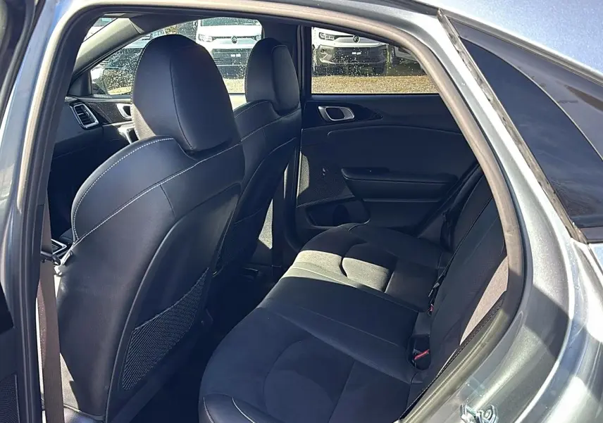 Vue intérieure côté droit arrière du Kia Xceed gris 2024, montrant les sièges en tissu et cuir avec appuie-têtes.