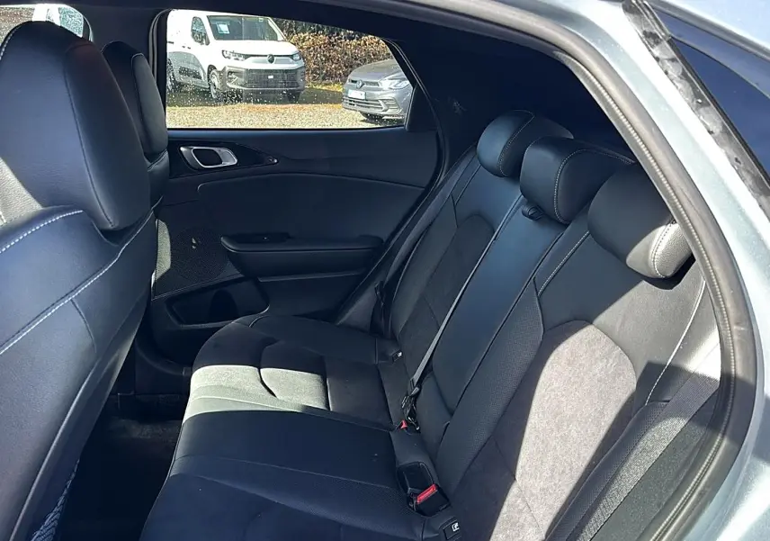 Vue intérieure côté droit des sièges arrière en tissu noir du Kia Xceed gris 2024 avec appuie-têtes et ceinture de sécurité.