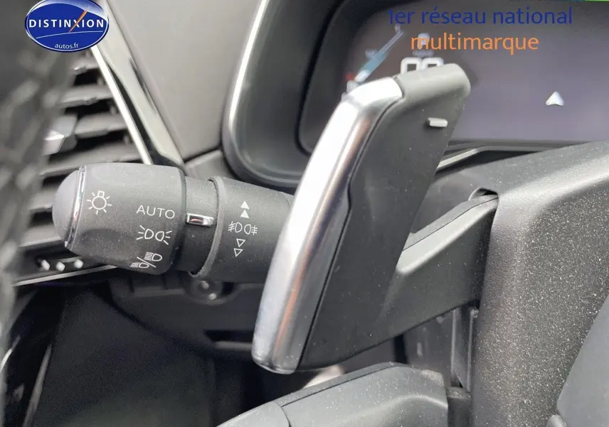 Gros plan sur la commande des phares et la palette de changement de vitesse du DS7 Crossback gris platinium intérieur.