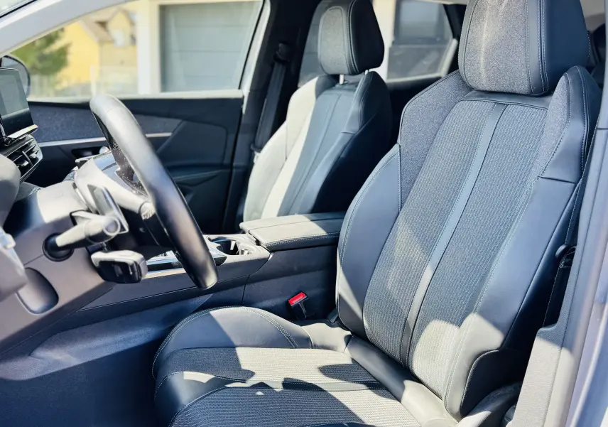 Vue intérieure côté conducteur du Peugeot 3008 2021, sièges en TEP tissu gris avec surpiqûres contrastées.
