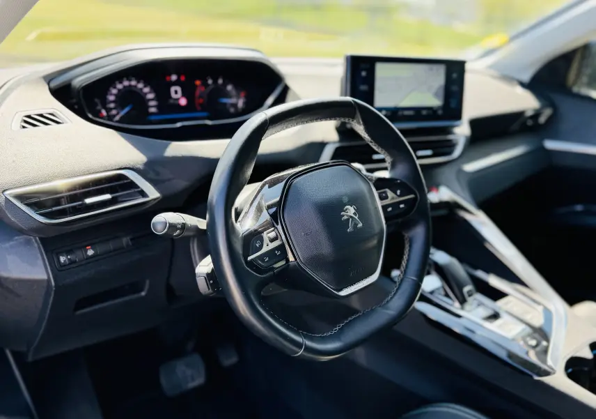 Intérieur du Peugeot 3008 gris Artens, vue du poste de conduite avec volant compact et écran tactile central.