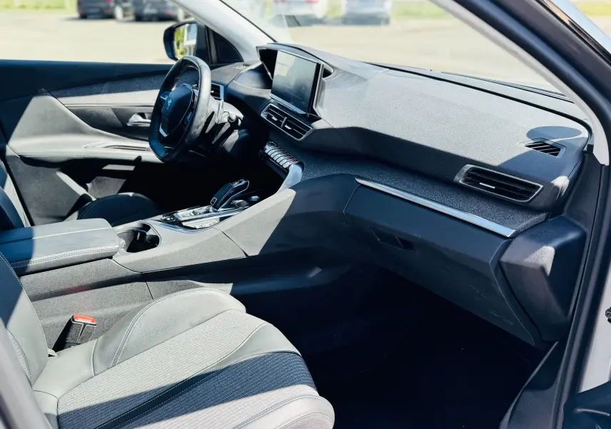 Intérieur côté conducteur du Peugeot 3008 gris Artens, tableau de bord moderne avec écran tactile et volant multifonction.