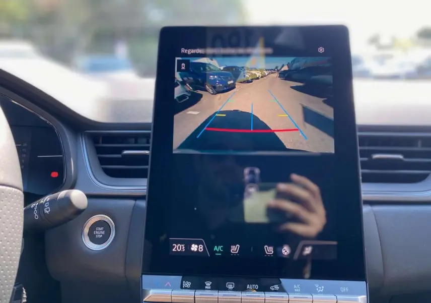Vue intérieure centrée sur l'écran tactile affichant la caméra de recul du Renault Captur gris Rafale 2025.