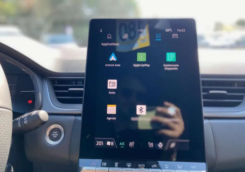 Vue rapprochée de l'écran tactile central vertical du tableau de bord du Renault Captur gris Rafale avec toit noir.