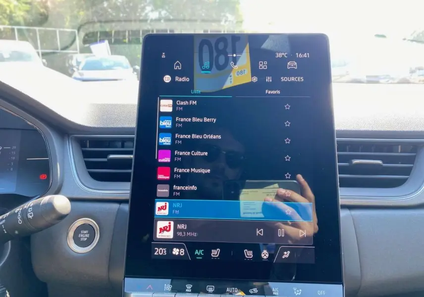 Écran tactile central du tableau de bord du Renault Captur gris Rafale, affichant les stations radio FM avec commandes tactiles.