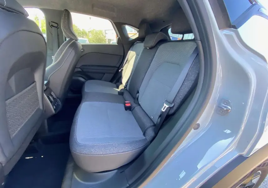 Vue côté droit de la banquette arrière grise du Renault Captur 2025 avec porte ouverte et sellerie tissu.