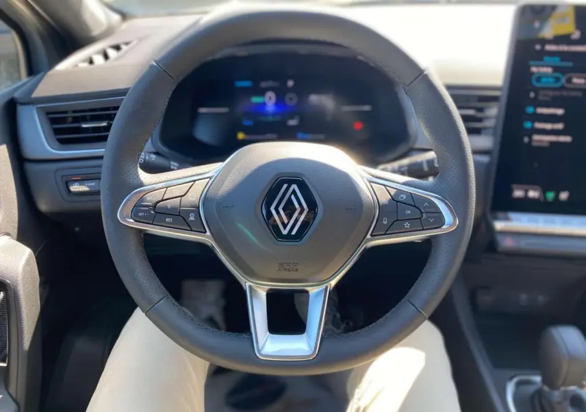 Volant multifonction Renault Captur 2025 en gros plan, avec tableau de bord numérique et écran tactile à droite.