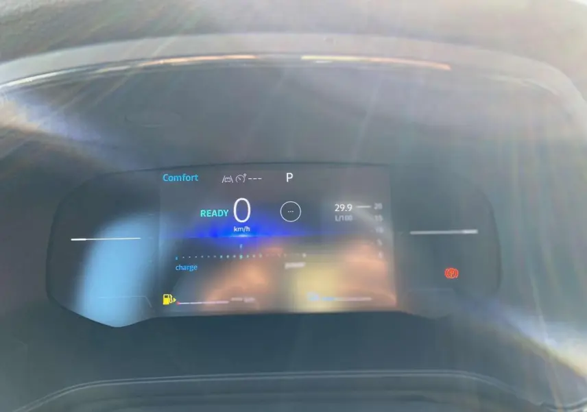 Tableau de bord numérique du Renault Captur 2025 en mode confort, affichant vitesse zéro et indicateurs hybrides.