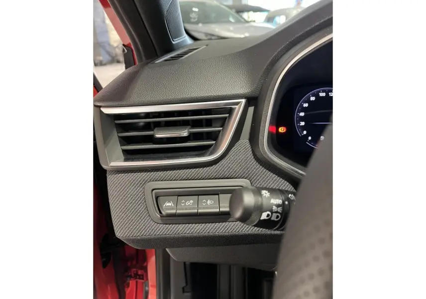 Détail de la console gauche avec aérateur chromé et commandes d'assistance sur Renault Clio rouge 2024 Esprit Alpine.