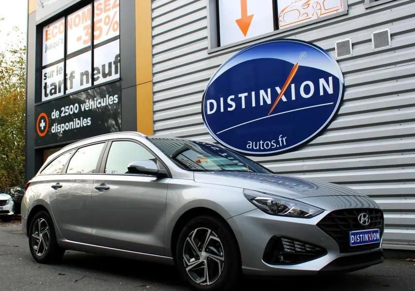 Hyundai i30 SW 2024 argent vue 3/4 avant droit, avec calandre noire et jantes alliage distinctives.