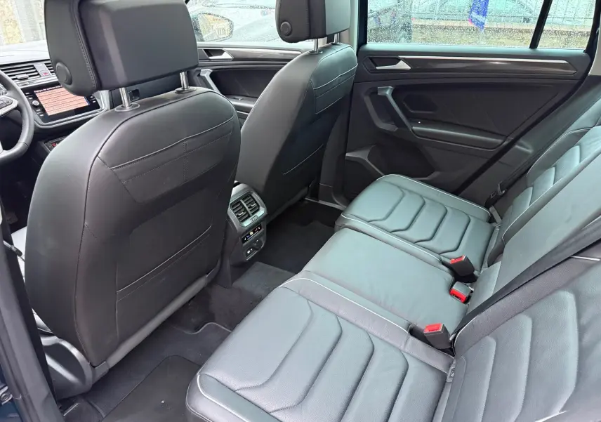 Intérieur cuir noir du Volkswagen Tiguan 2022 vu côté droit, mettant en valeur les sièges arrière et la console centrale.