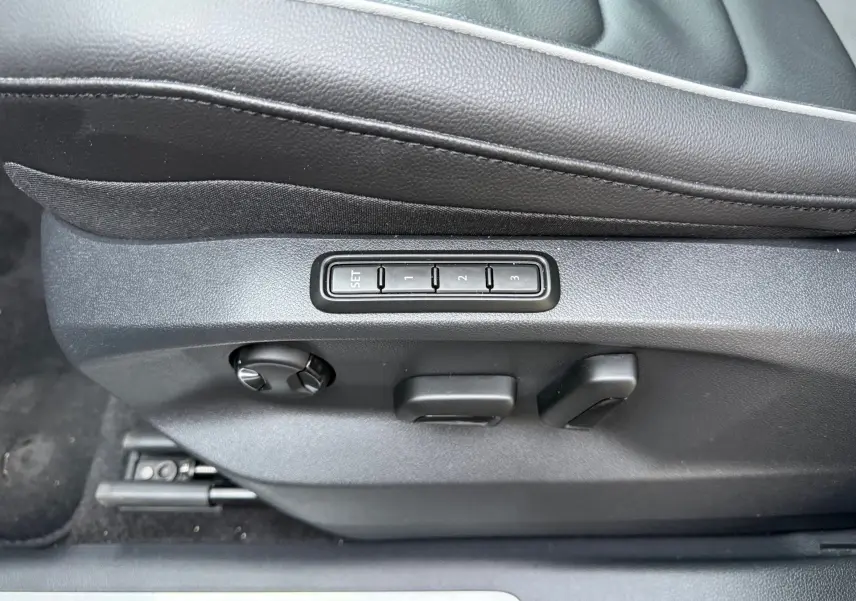 Réglages électriques du siège conducteur noir en cuir du Volkswagen Tiguan 2022, boutons de mémorisation visibles.