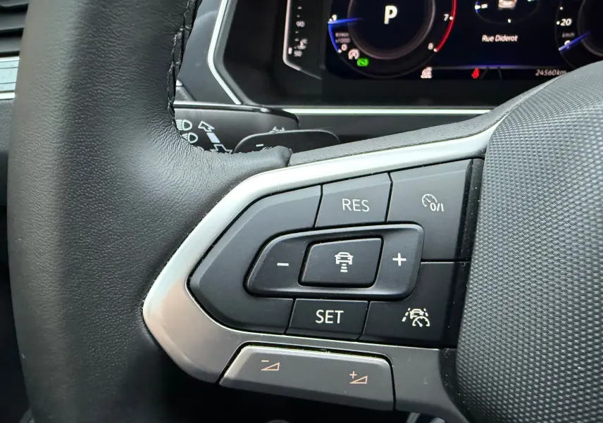 Gros plan sur les commandes au volant du Volkswagen Tiguan 2022, avec boutons de régulateur de vitesse et assistance conduite.