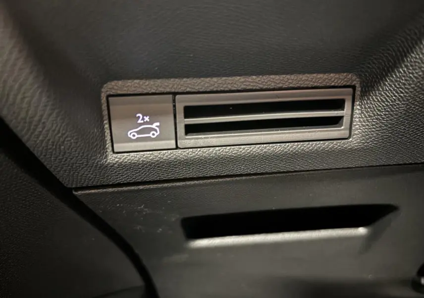 Détail du bouton d'ouverture du hayon sur console intérieure noire du Peugeot 3008 Gris Artense.