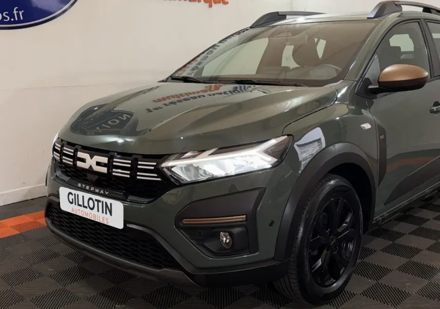 Vue 3/4 avant droite d'une Dacia Sandero Extreme+ TCe 110 2024 vert avec rétroviseurs bronze et jantes noires.