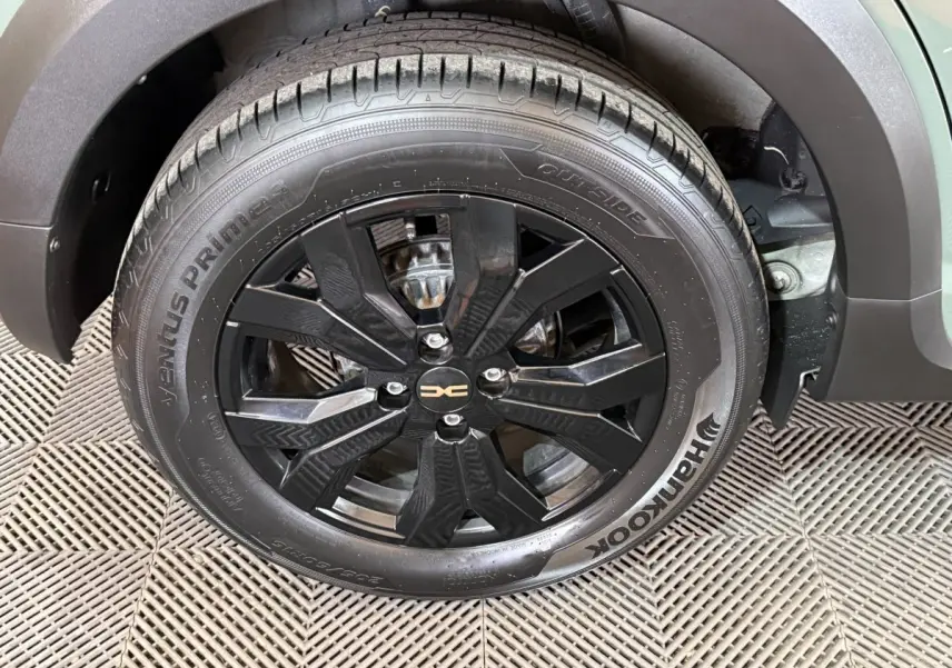 Gros plan sur la roue avant droite noire avec jante alliage du Dacia Sandero Extreme+ vert 2024.
